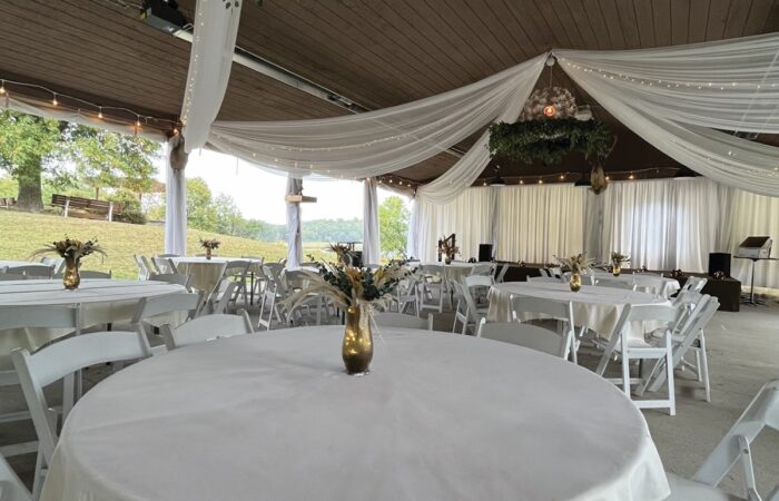 An outdoor pavilion, with white wedding cloth draped elegantly from the ceiling