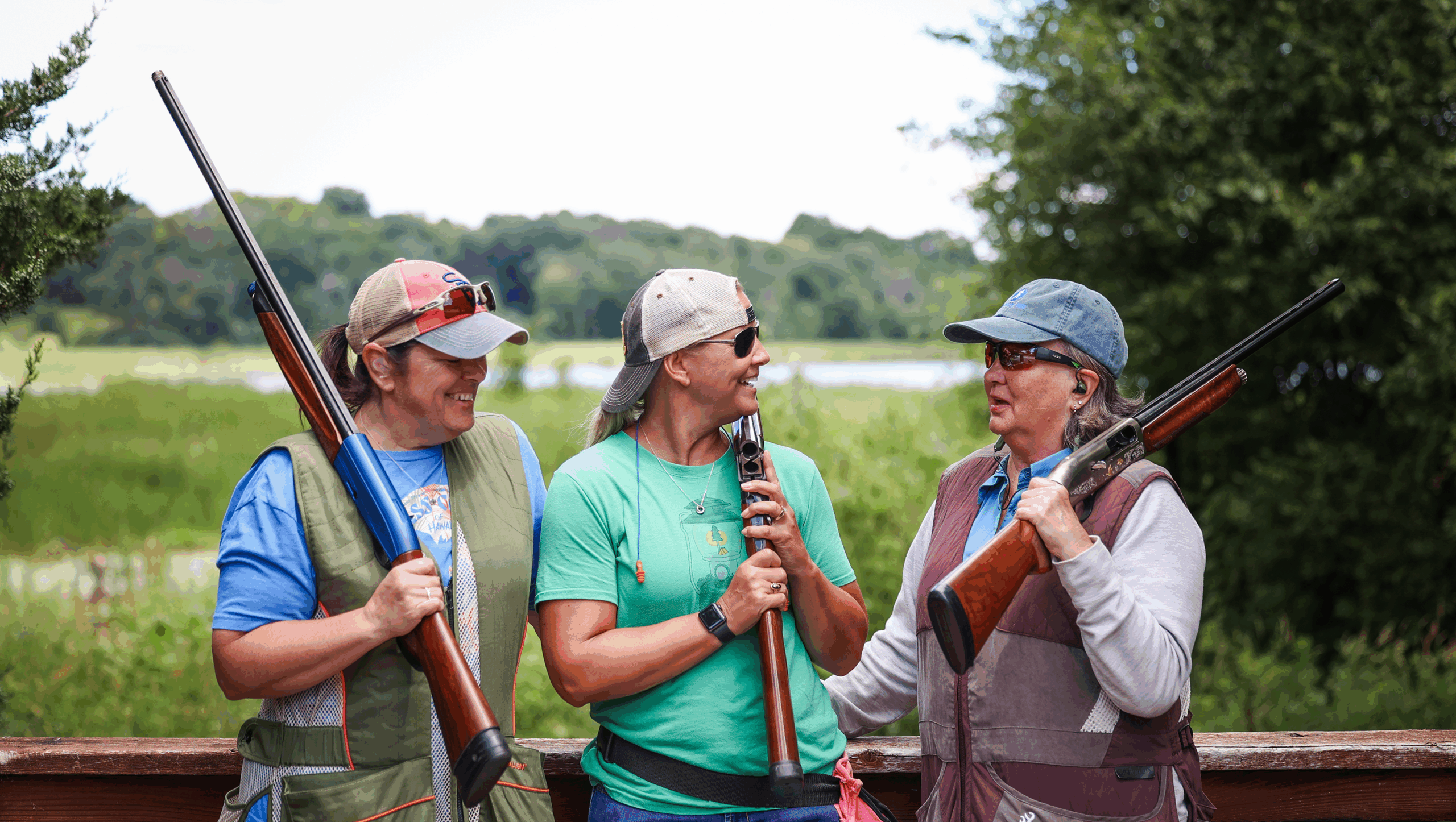 Three women on a balcony, smiling.