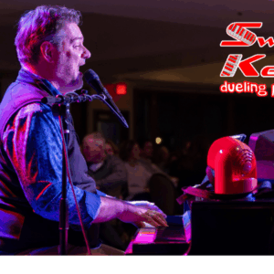 Man playing the piano and singing into a microphone