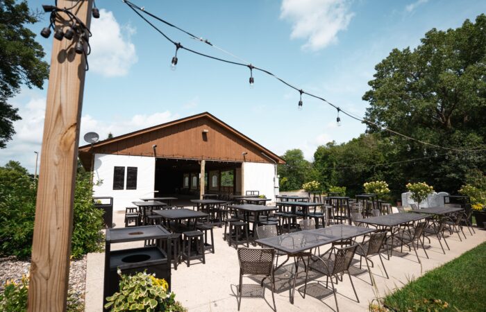 A-frame pavilion with tables and chairs out front on patio