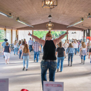 group of people line dancing in a pavilion
